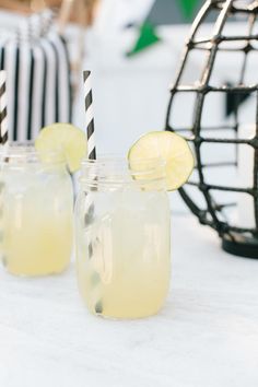 three glasses filled with lemonade sitting on top of a table