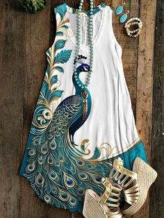 a peacock print dress and sandals on a wooden floor with beads, pearls, and necklaces