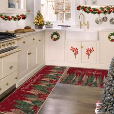 a kitchen decorated for christmas with red and green rugs on the floor next to stove