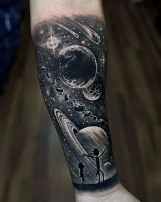 a man with a black and white tattoo on his arm that has an image of the planets