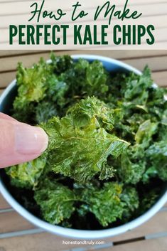 Closeup of a hand holding a kale chip over a bowl of other baked kale chips. Baked Kale Chips, Garlicky Kale, Vegan Chips, Kale Chips Baked, Crispy Kale, Baked Kale, Kale Chip Recipes, Paleo Snack, Gluten Free Meal Plan