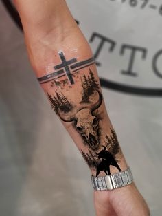 a person with a tattoo on their arm that has a deer and cross on it