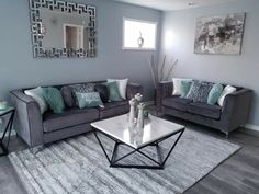 a living room with two couches and a coffee table in front of a mirror