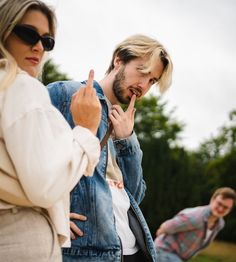 two people standing next to each other with one pointing at the other's finger