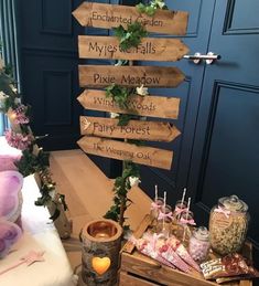 a wooden sign sitting on top of a table next to a vase filled with flowers