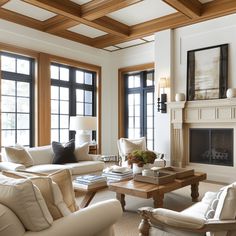 a living room with couches, chairs and a table in front of two windows