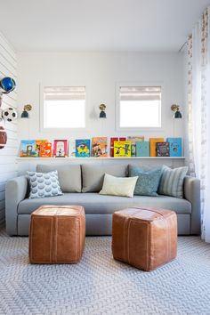 a living room filled with lots of furniture next to two windows and pictures on the wall