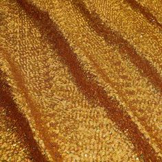 an orange and gold colored fabric with small circles on the top, as if it were sequins