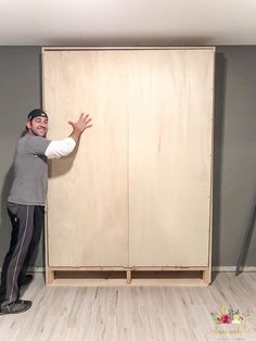 a man standing in front of a wooden closet