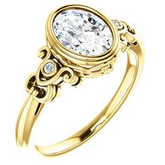 a yellow gold ring with an oval cut diamond in the center, surrounded by filigrees