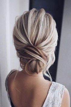 the back of a woman's head with blonde hair styled into a low bun