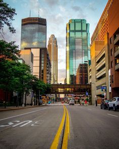 an empty city street with tall buildings in the background