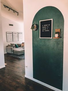 a living room with green walls and a chalkboard on the wall