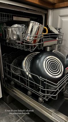 an open dishwasher with pots and pans in it