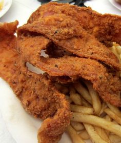 fried chicken and french fries on a white plate with dipping sauce in small bowls next to them