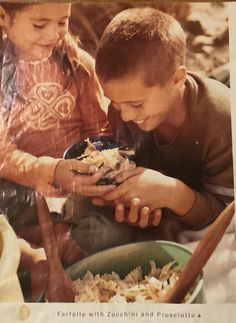 two children are eating food out of a bowl