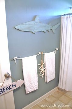 two white towels hanging on the wall next to a towel rack in a blue bathroom