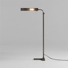 a lamp that is on top of a white surface with a black cord attached to it