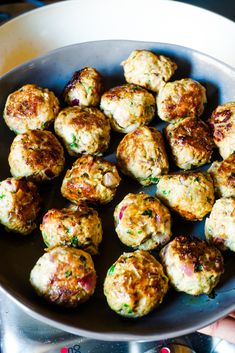 a pan filled with meatballs on top of a stove