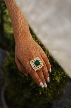 The gold plated polki ring is a combination of heritage and contemporary forms handcrafted by the artisans of India with carved emerald to celebrate perfect armor between old and modern concepts. The Indian polki ring is a beautiful work of art with a royal touch to adorn your hand and be a companion on your special days. Pair this stone ring, which is a replica of Sabyasachi jewelry with your Indian or contemporary ensemble, and complete the look. Closure - Adjustable Style Tip - This delicate Indian Emerald Ring, Indian Traditional Stone Rings, Emerald Ring Indian, Luxury Meenakari Emerald Jewelry, Indian Traditional Rings, Gemandi Ring, Luxury Green Hand Set Chandbalis, Luxury Elegant Meenakari Rings, Luxury Hand Set Green Chandbalis