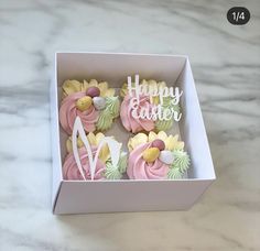 some cupcakes that are in a box on a table with the words happy easter written on them