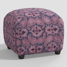 a pink and blue ottoman sitting on top of a white floor