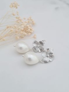 Stunning mother of pearl coated pearl drops with silver plated flower studs.  These earrings are classic and can be worn for your special occasion or every day. They are 1.25in/3cm in length. Silver Pearl Drop Flower-shaped Earrings, Silver Flower Earrings With Pearl Drop, Silver Sterling Flower Earrings With Pearl Drop, Silver Drop Earrings With Flower Charm For Bridal, Elegant Flower Teardrop Earrings For Gift, Elegant Flower Shaped Teardrop Earrings, Silver Sterling Pearl Drop Flower Earrings, Silver Drop Bridal Earrings With Flower Charm, Silver Bridal Drop Earrings With Flower Charm