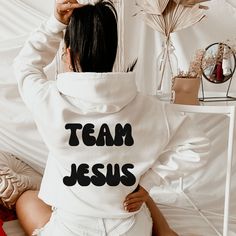 *RECOMMEND SIZING UP TO LOOK OVERSIZED* Team Jesus Sweatshirt ,Aesthetic Sweatshirt, Oversized Sweatshirt, Pinterest Hoodie, Words On Back, Hoodie, VSCO, Trendy Hoodie, Tumblr Hoodie, Aesthetic Hoodie, Perfect gift, Aesthetic Clothes Trendy Y2k **Words are printed on the back of the sweatshirt** Gildan Unisex Sweatshirt, Hoodie 50% Cotton 50% Polyester Medium-heavy fabric (8.0 oz/yd² (271.25 g/m ✔Make sure you check our size-chart before you place your order. We have size chart on our listing ph White Slogan Crew Neck Hoodie, White Tops With Team Spirit Lettering, White Crew Neck Hoodie With Slogan, White Graphic Print Crew Hoodie, White Hoodie With Letter Print For Team Spirit, White Text Print Hoodie Tops, White Text Print Hoodie, White Team Spirit Hoodie Sweatshirt, White Hoodie With Lettering In Relaxed Fit