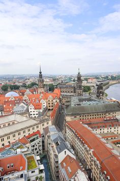 an aerial view of the city with red roofs and water in the background, from above