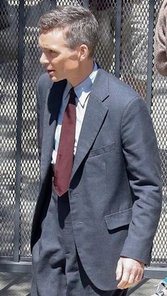 a man in a suit and tie walking down the street