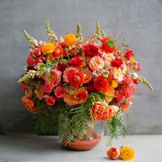 a vase filled with lots of orange and red flowers