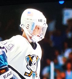 an ice hockey player wearing a white uniform