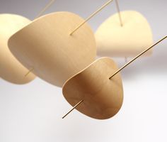 three wooden objects hanging from the ceiling with pins sticking out of them and two are on top of each other