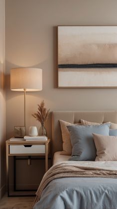 a bed sitting under a painting on top of a wall next to a night stand