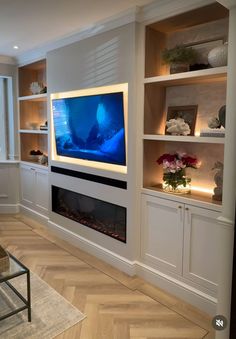 a living room filled with furniture and a flat screen tv mounted on a wall above a fireplace