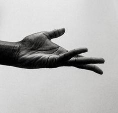 a person's hand reaching out towards the sky