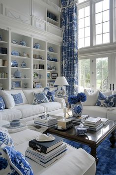 a living room with blue and white decor on the walls, bookshelves and couches