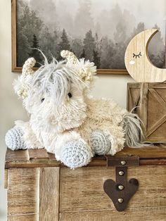 a white stuffed animal sitting on top of a chest