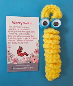 a crochet worm with googly eyes is next to a card that says worry worm