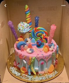 a birthday cake decorated with candy and candies in a cardboard box for a child's birthday