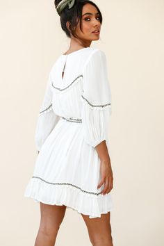 White tunic style dress  Partially lined  Three-quarter sleeves  Removable waist tie  Pom-pom trim detail  Non stretchy   Breeze through your day in our boho-chic Marionette dress. It's super versatile and we are loving the pom-pom trim detail. Perfect for lunch dates with your girls paired with ankle boots and a felt hat or dress it up with tan mules and some gold hoops for a chic look we are loving. Summer Dress With Ruffle Hem And 3/4 Sleeves, Summer Dresses With Ruffle Hem And 3/4 Sleeves, Flowy Dresses With 3/4 Sleeves For Vacation, Bohemian Flowy Mini Dress With Ruffle Hem, Bohemian Dresses With 3/4 Sleeves For Vacation, Bohemian 3/4 Sleeve Dresses For Vacation, Bohemian 3/4 Sleeve Vacation Dresses, Flowy 3/4 Sleeve Dress For Brunch, Flowy Brunch Dress With 3/4 Sleeves