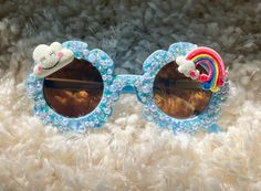 Rainbow Cloud Sunglasses handmade for your fabulous & fun toddler/child!    * for kids ages 1 to over 5  * (check the size below before ordering if you are unsure.)   * Sunglasses bag provided for protection.  Perfect for outdoor activities, photoshoots, birthday parties, party favors, classroom gifts, beach, traveling, etc.!  If you have any other custom ideas, or clarifications, feel free to message me directly! I am open to custom designs.  *Please note that if you request a different customization, I am likely able to do it, but it may take longer if I do not have the supplies available at the time of request. I will guarantee that I will do my best to oblige to custom orders within reasonable requests. *  No refunds or returns.  If there is an issue upon arrival of product - please co Fun Handmade Sunglasses As A Gift, Fun Handmade Plastic Sunglasses, Handmade Fun Plastic Sunglasses, Handmade Plastic Fun Sunglasses, Fun Sunglasses With Gradient Lenses For Gift, Playful Adjustable Sunglasses As A Gift, Whimsical Adjustable Sunglasses With Uv Protection, Fun Handmade Adjustable Sunglasses, Blue Tinted Sunglasses As Gift