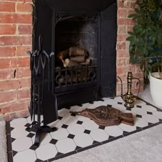 a fireplace with a black and white tile floor next to a potted green plant