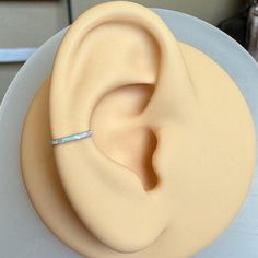 a close up of a cake with a fake ear on the top and a ring in the middle