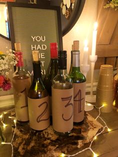 several wine bottles with numbers on them sitting on a table in front of a sign