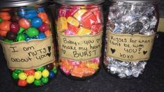 three jars filled with candy and candies sitting on top of a black countertop