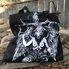 "Baphomet Large Tote Bag THIS ITEM IS MADE TO ORDER Classic tote shape with oversized dimensions of 20\" wide, 15\" tall and 4\" deep Poly Canvas fabric Navy blue inner liner with 1 zipper pocket and 1 double pocket for organization 1.5\" wide cotton webbing strap in black Artwork by: Nat Jones" Black Alternative Style Bags, Black Gothic Shoulder Bag, Black Gothic Tote Shoulder Bag, Gothic Black Bags With Large Capacity, Alternative Style Black Bags For Festivals, Black Gothic Bag With Large Capacity, Gothic Large Capacity Black Bag, Gothic Large Capacity Shoulder Bag, Gothic Black Bag For Alternative Fashion