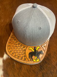 Richardson hat with a hand-tooled leather bill that has been hand sewn to the original bill. Western Flat Brim Baseball Cap For Rodeo, Western Style Baseball Cap With Short Brim, Western Snapback Hat For Country Events, Country Style Snapback Hat For Rodeo With Flat Brim, Western Snapback Hat With Curved Brim For Rodeo, Country Style Flat Brim Snapback Hat For Rodeo, Western Style Snapback Hat With Short Brim, Western Style Snapback Hat, Western Snapback Hat For Ranch