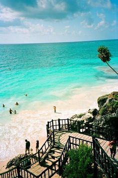 stairs lead down to the beach as people play in the water