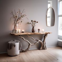 a wooden table topped with candles next to a mirror